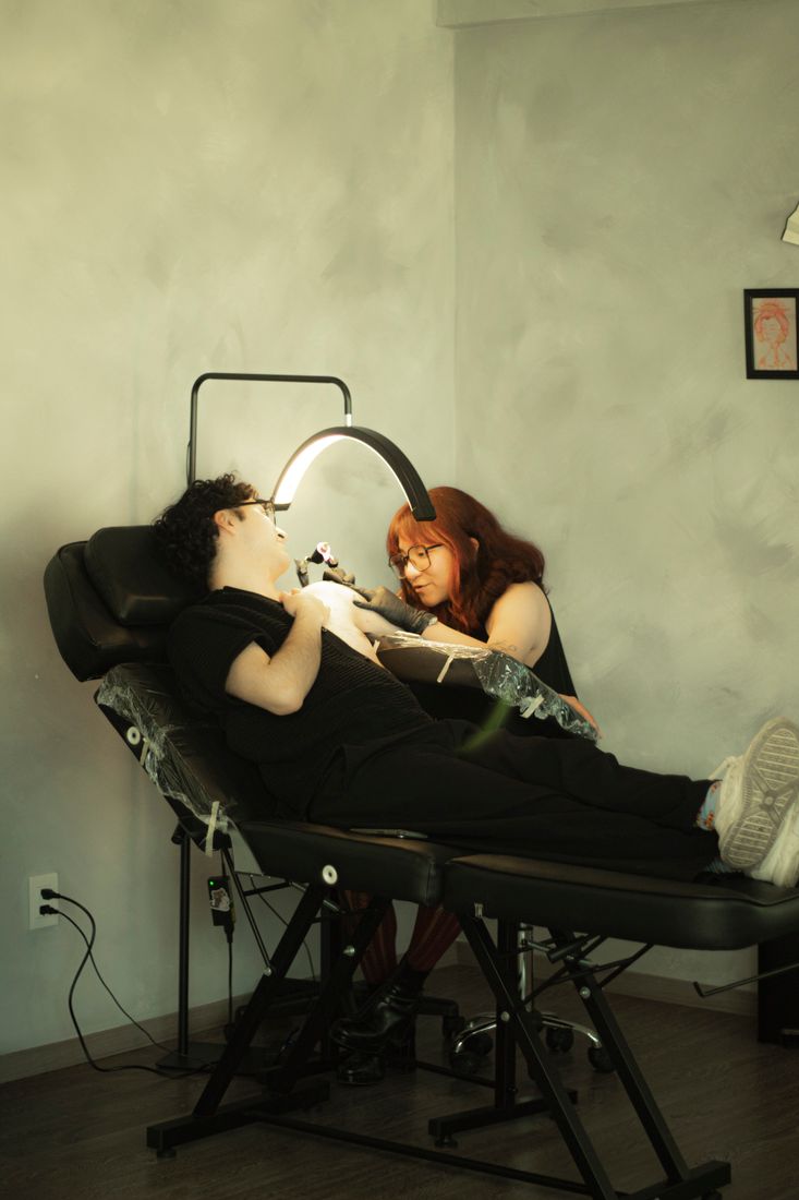 Artista a trabalhar num estúdio de tatuagem